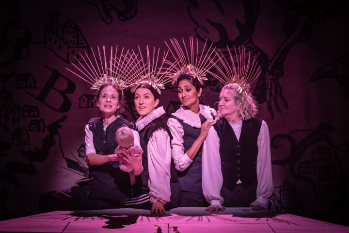 Faye Castelow, Amalia Vitale, Natasha Jayetileke, Debra Gillett wearing headdresses in pink lighting
